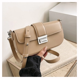 Detail of cream matte leather crossbody bag featuring a silver rectangular metal clasp
