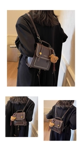 Detail of dark brown leather mini backpack with gold studs and cute plush bear charm