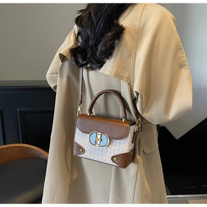 Detail of the elegant two-tone brown and white snake pattern leather crossbody box bag