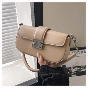 Detail of beige baguette bag with metallic silver buckle and elegant chain strap