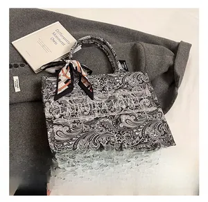 Dettaglio del ricamo paisley sulla borsa tote con foulard decorativo sul manico