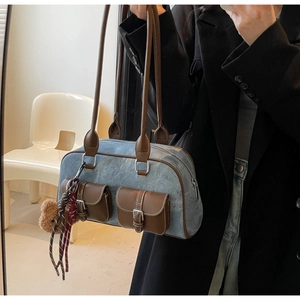 Detail of Boston tote bag in blue denim and brown leather with double buckle pockets