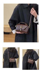 Detail of vintage brown square handbag featuring matte leather and golden buckle clasp