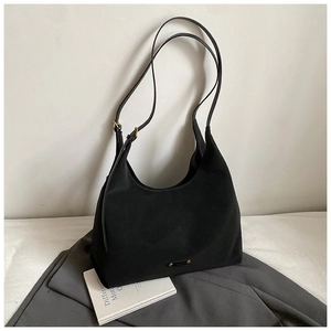 Detail of a black half-moon tote bag with slender straps and a gold metal logo plate