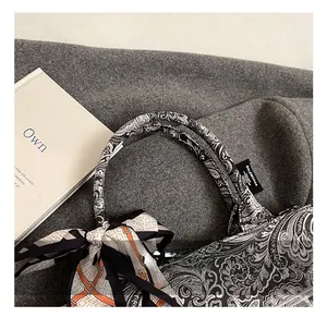 Dettaglio della borsa a mano con motivo paisley bianco e nero con nastro e etichetta nera