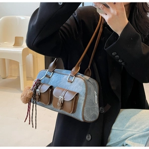 Mirror selfie showing a blue denim shoulder bag with brown leather trim and bear charm