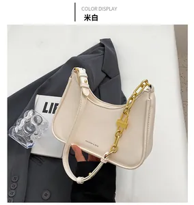 Close-up of cream crescent underarm bag with gold chain strap and elegant leather texture