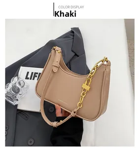 Detail view of khaki shoulder bag with thick gold chain and fashion logo on leather