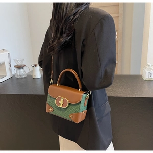 Detail view of mini vintage handbag featuring green woven texture and brown leather accents
