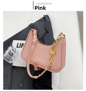 Detail of pink hobo bag featuring smooth leather and gold chain lock decoration