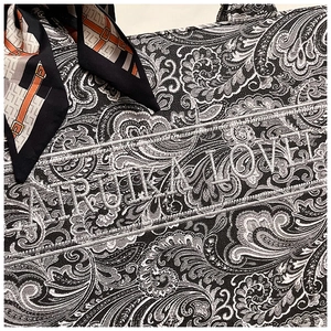 Dettaglio del ricamo paisley e della sciarpa di seta su una grande borsa tote in tela