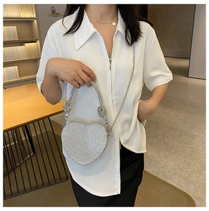 Gros plan sur le sac de soirée cœur argenté étincelant avec strass et chaîne en métal