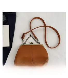 Détail du sac à main marron texture lychee avec fermoir rétro à double perle et chaîne en métal