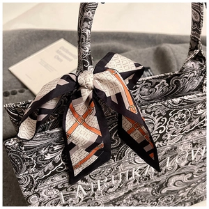 Dettaglio della borsa tote in tela paisley con fiocco in seta e ricamo chic
