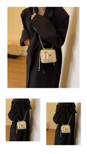 Gros plan sur un mini sac en tweed crème avec chaîne dorée sur un manteau noir