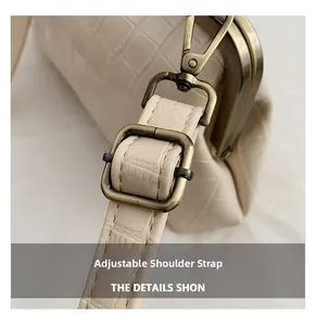 Detailed close-up of adjustable strap with crocodile texture and bronze metal hardware