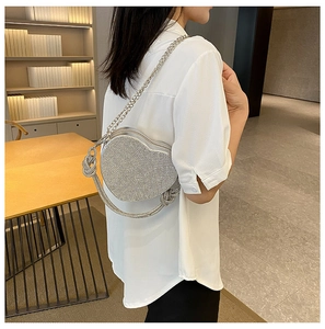 Détail du sac à main en strass en forme de cœur avec chaîne en métal sur l'épaule