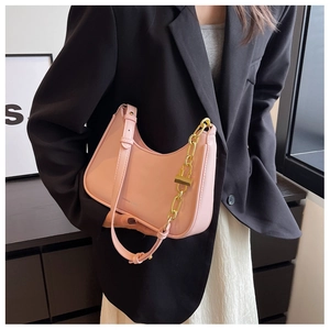Detail of pink hobo bag featuring matte PU texture and golden metal chain strap