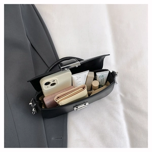 Top view of black faux leather bag showing internal storage for phone and cosmetics