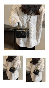 Détail du mini sac en tweed noir avec fleur dorée et bandoulière en chaîne élégante