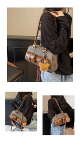 Detail of vintage canvas Boston bag with front pockets, plush bear and silk scarf