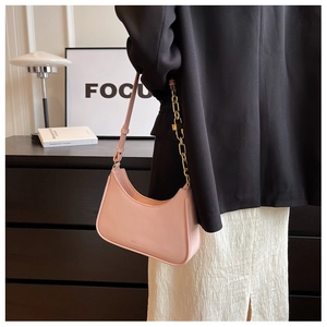 Close-up of pink hobo bag with gold chain strap and smooth leather texture for women