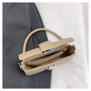 Detail view of beige crossbody bag interior featuring zipper pocket and silver turn-lock