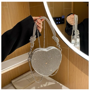 Détail du sac de soirée argenté en forme de cœur orné de strass en cristal scintillants