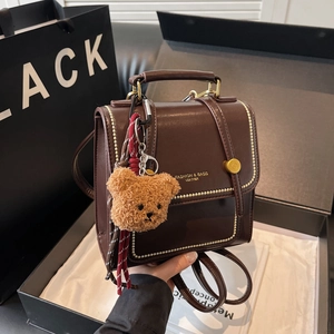 Deep brown leather vintage backpack for women with gold hardware and bear charm