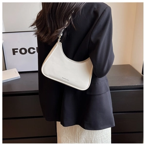 White minimalist hobo bag worn by model showing the size ratio and sleek shoulder fit