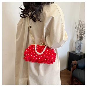Détail du sac de soirée en mousseline rouge avec perles et chaîne dorée sur un modèle