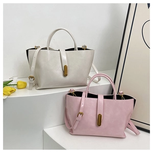 Detail view of cream and pink tote bags with gold metal clasps and long straps