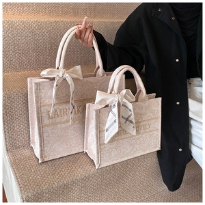 Dettaglio di borse tote con motivo paisley e sciarpa di seta decorativa sulle scale
