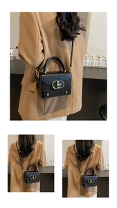 Detail of elegant black box bag with golden metal buckle and woven texture trim