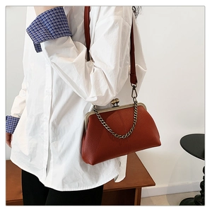 Détail du sac coquillage marron rouge avec fermoir baiser et chaîne dorée