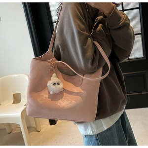Pink PU leather tote bag detail with fashion logo embossing and white plush charm