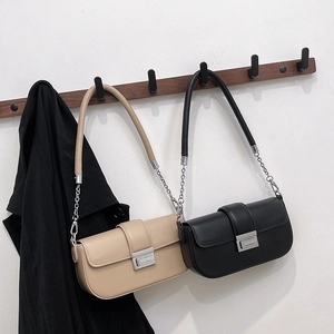 Fashionable minimalist baguette bag in black and beige leather with silver chain strap