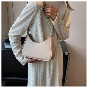 Close-up of beige hobo bag with gold chain strap and Fashion & Bag lettering