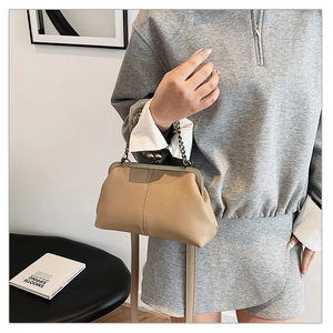 Détail du sac à main beige vintage avec texture grainée et fermoir à perles dorées