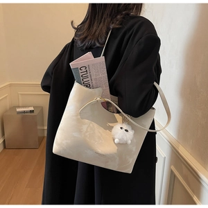 Close-up of marble texture tote bag with fluffy pompom charm and fashion lettering