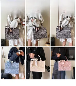 Dettaglio di borse tote in tela stampata con motivi paisley e sciarpe decorative in seta