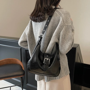 Modern black glossy leather hobo bag with silver buckle and vintage eyelet strap