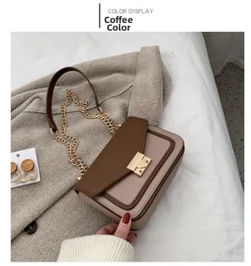 Detail of coffee and beige leather crossbody bag with gold metal lock on wool coat