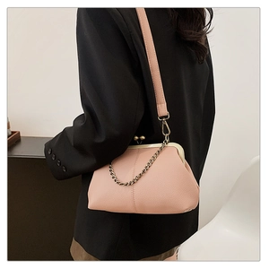 Détail du sac vintage rose avec texture cuir grainé et bandoulière chaîne bronze