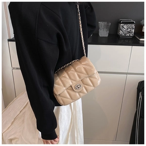 Détail du sac à bandoulière matelassé brillant avec fermoir rotatif et bandoulière chaîne