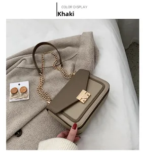Detailed view of khaki and beige crossbody bag with gold chain and metal snap closure