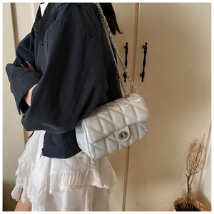 Détail du sac bandoulière matelassé blanc avec fermoir rotatif argenté et chaîne métal