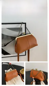 Détail d'un sac vintage marron en cuir litchi avec fermoir clic-clac et chaîne dorée