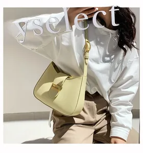 Detail of light yellow baguette bag with gold metal buckle and matte leather texture