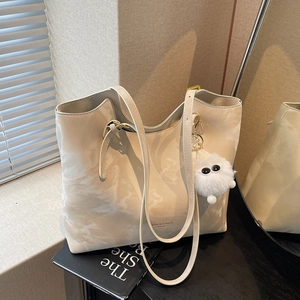 Minimalist beige marble pattern tote bag with plush charm on a lifestyle background